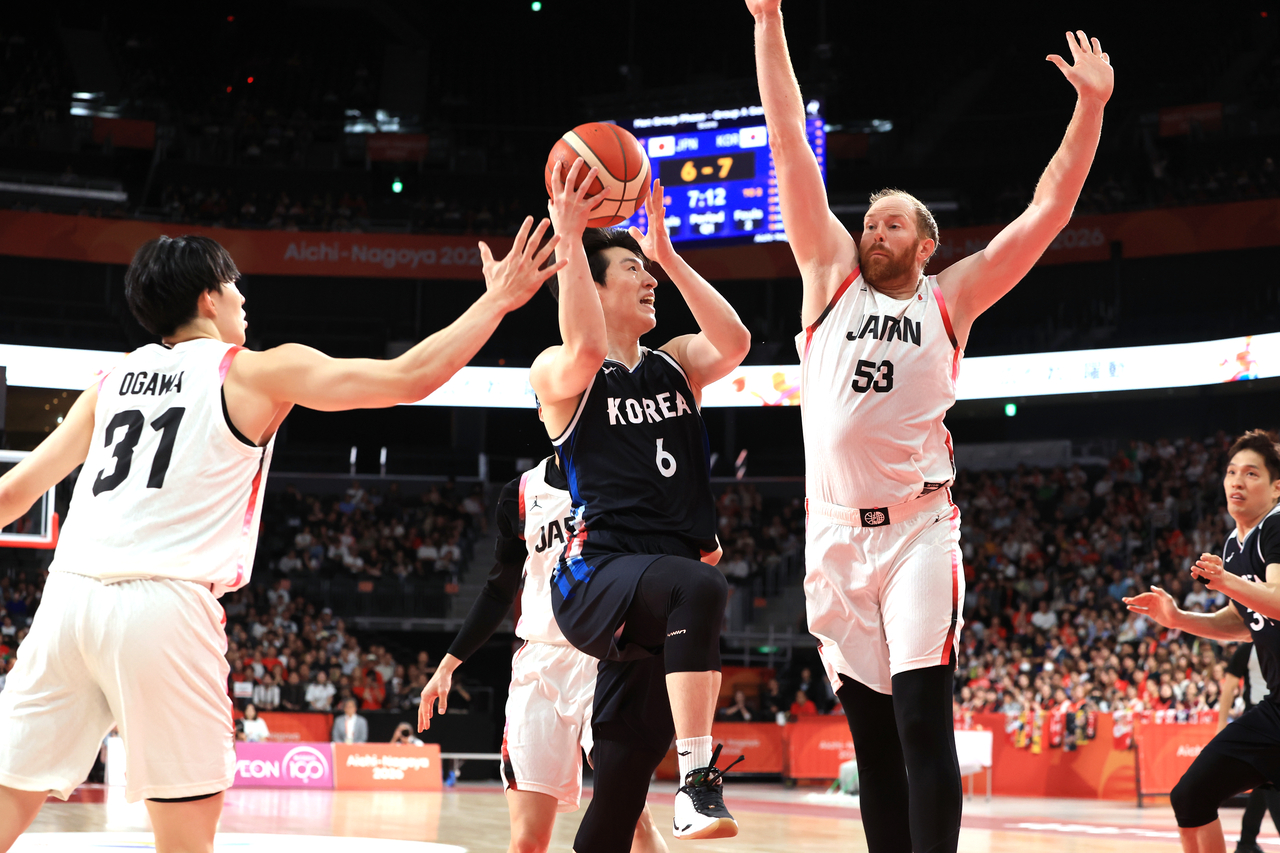 Lee Jung-hyun of South Korea (center) attempts a shot over Alex Kirk of Japan (right) during the teams' Group A game of the men's basketball tournament at the Asian Games at Aichi International Arena in Nagoya, Japan, on Sunday. (Yonhap)
