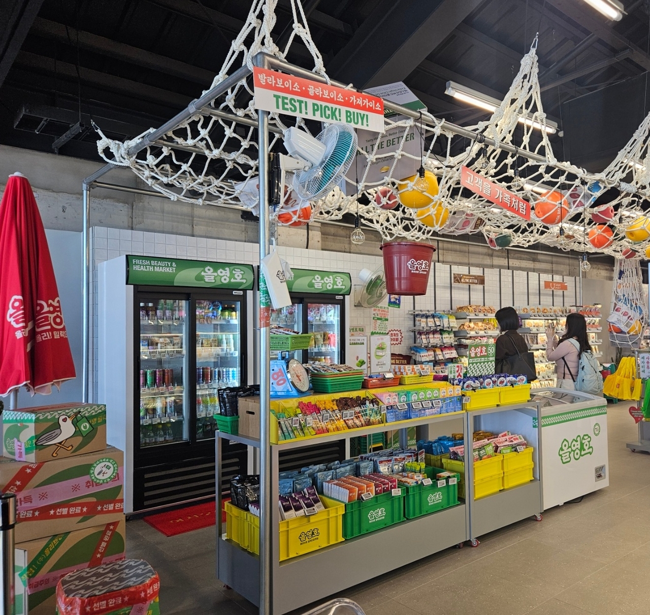 Inside CJ Olive Young Millak the Market, fishing nets, parasols and product boxes stacked as if freshly unloaded from a ship set the nautical mood. A freezer bearing the name "Olive Young Ship" stocks ice cream and cups of ice. The store is the first CJ Olive Young location to sell ice cream. [Kim Jin]