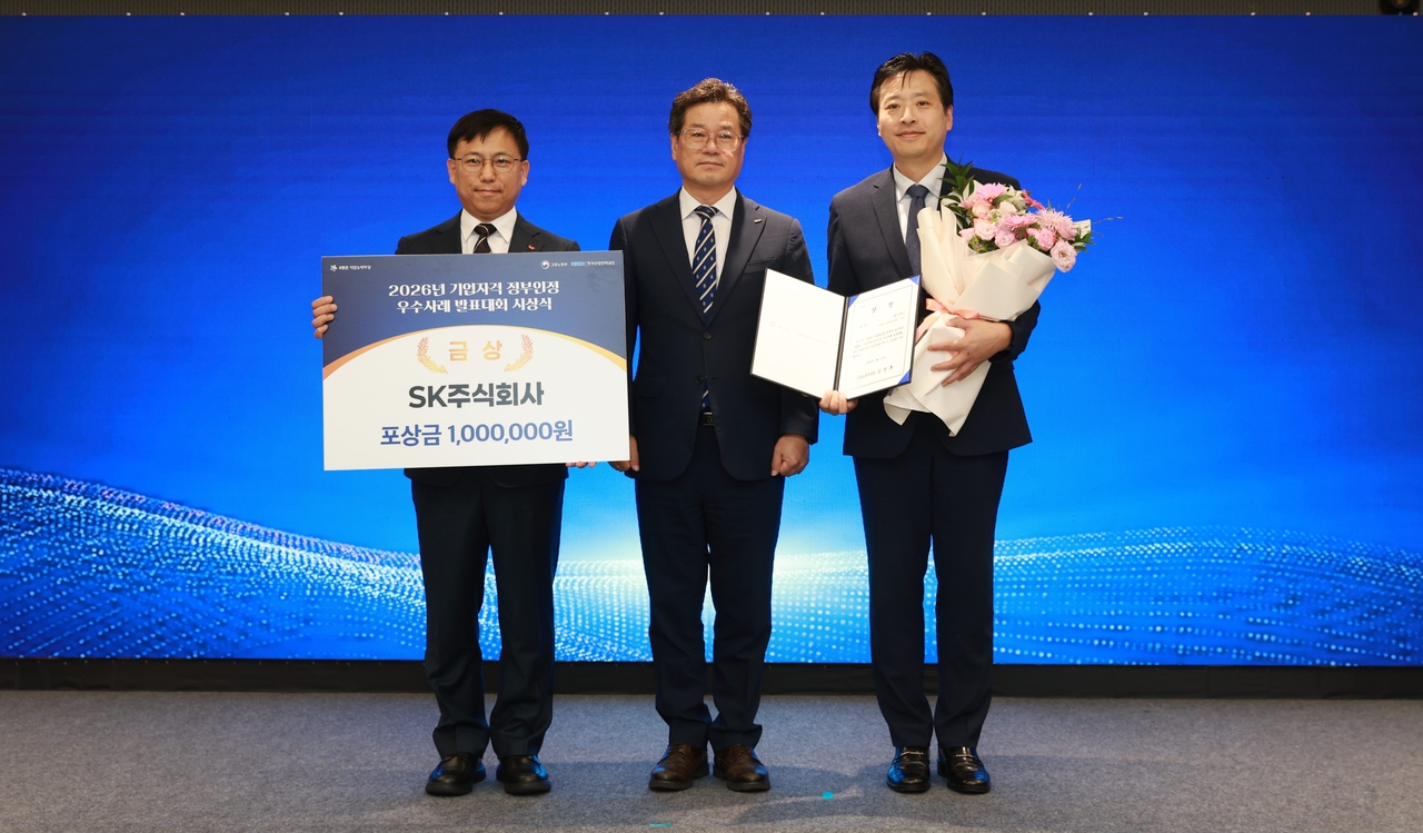 Jung Dae-ryeong (from left), head of SK AX's AX Education Business Team 1; Cheon Hak-gi, competency assessment director at the Human Resources Development Service of Korea; and Kim Min-hwan, head of SK AX's HRX promotion division, pose for a photo at the awards ceremony held Friday at COEX Magok in Seoul. [SK AX]