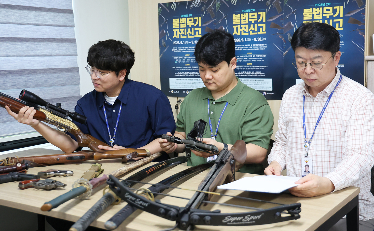 Police officers inspect illegal weapons voluntarily surrendered by their owners during a self-reporting period at Suwon Jangan Police Station in Suwon, Gyeonggi Province, on Sept. 1. (Yonhap)