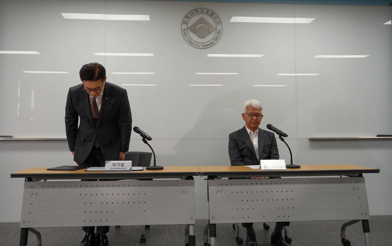 Korean Council for University Education President Lee Ki-jeong (left) bows in apology at a press conference Monday at the KCUE headquarters in Geumcheon-gu, Seoul. (KCUE)