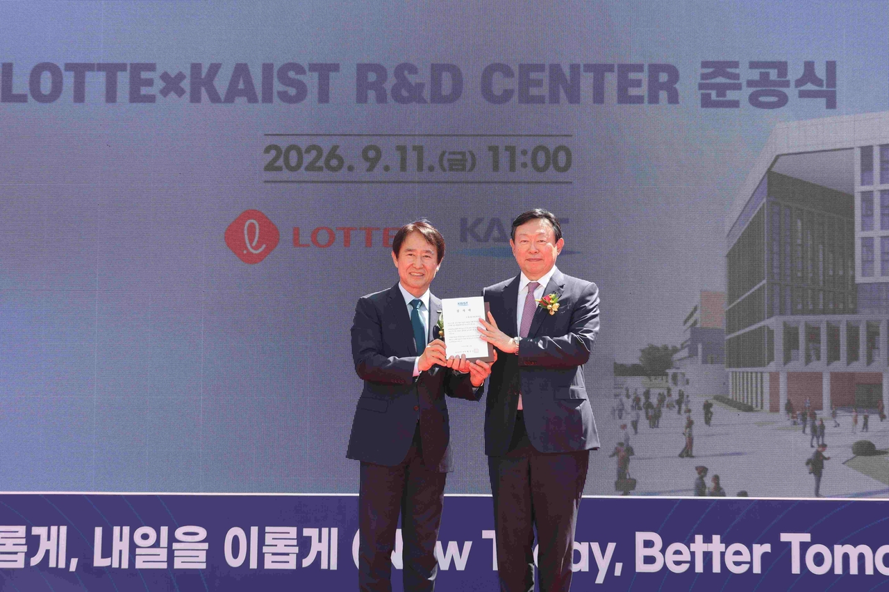 KAIST President Bae Choong-sik (left) presents Lotte Group Chairman Shin Dong-bin with a plaque of appreciation at the inauguration ceremony of the Lotte x KAIST R&D Center at KAIST's main campus in Daejeon on Friday. [Lotte Group]