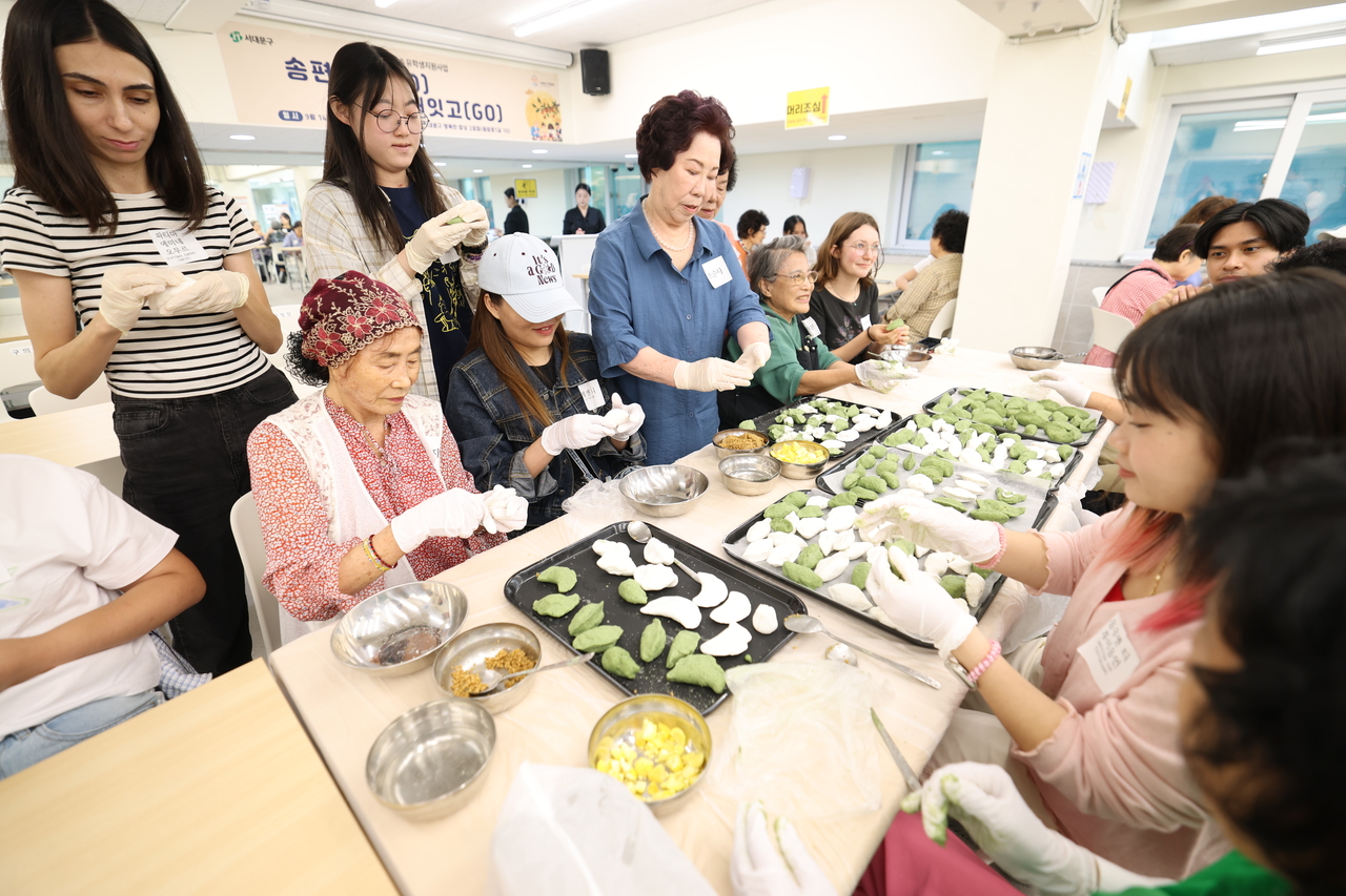 Participants make songpyeon at the “Shaping Songpyeon, Bridging Generations” event in Seodaemun-gu, Seoul, on Monday. (Seodaemun-gu Office)