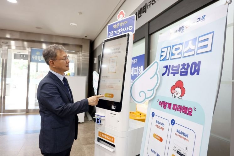 장인홍 서울 구로구청장이 구로구청 1층 현관에 설치된 ‘희망 기부 키오스크’를 작동해보고 있다. [구로구 제공]