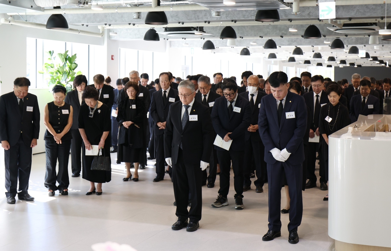 Ottogi Chairman Ham Young-joon (front row, left) and President Hwang Sung-man (front row, second from left), along with other executives and employees, observe a moment of silence after laying flowers at the memorial ceremony for late Honorary Chairman Ham Tae-ho at Ham Tae-ho Hall in Anyang, Gyeonggi Province, on Friday. [Ottogi]
