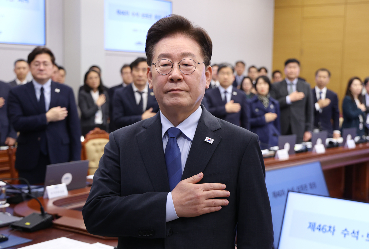 President Lee Jae Myung salutes the national flag at a senior staff meeting held at Cheong Wa Dae on Friday. [Yonhap]