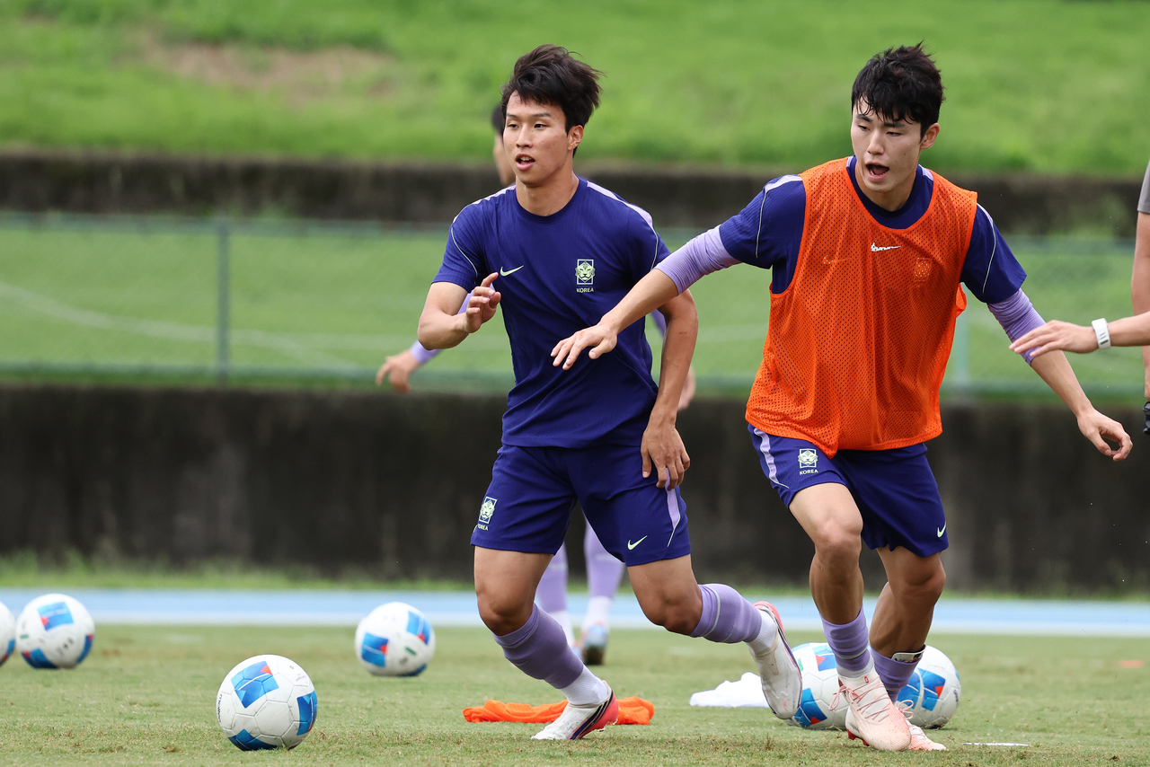 South Korean men's football team captain Lee Gi-hyuk (right) and midfielder Eom Ji-sung practice on Sunday at the Toyota Sports Center in Nagoya, Japan. (Yonhap)