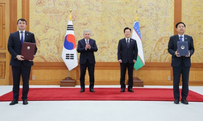 구윤철 재정경제부 장관과 잠시드 호자예프 우즈베키스탄 부총리가 14일 청와대에서 이재명 대통령과 샤브카트 미르지요예프 대통령이 임석한 가운데 고속철 8편성 도입 및 국가 유전체·바이오뱅크 ‘바이옴센터’ 센터 설립 관련 양해각서 문건을 교환한 뒤 기념 촬영을 하고 있다. [연합]