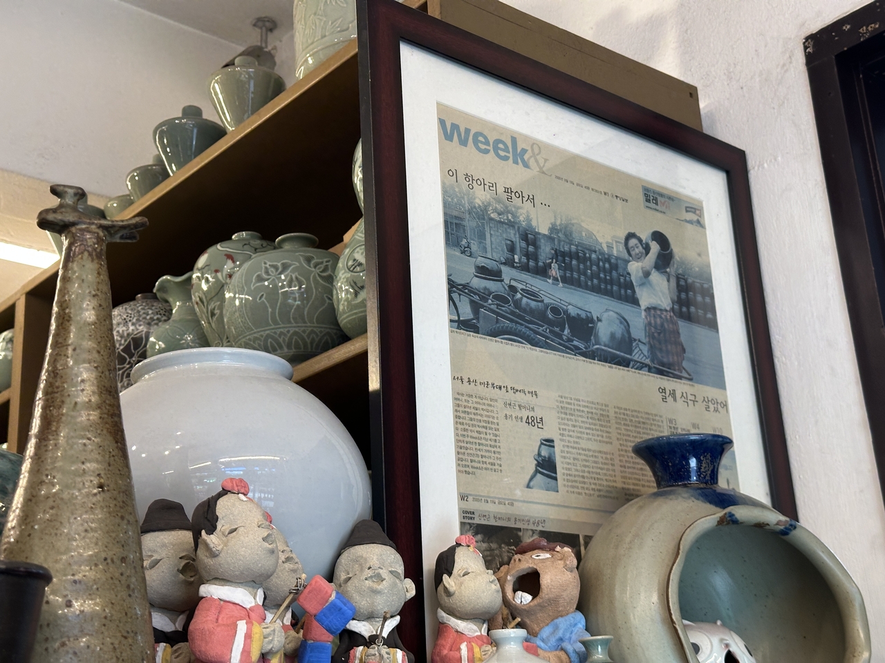 Shin Yeon-geun, a longtime Haebangchon figure who began selling onggi from a handcart in the neighborhood in the 1960s, is pictured in a newspaper clipping displayed inside Hanshin Onggi. Shin died in December 2024. (Tammy Park/The Korea Herald)