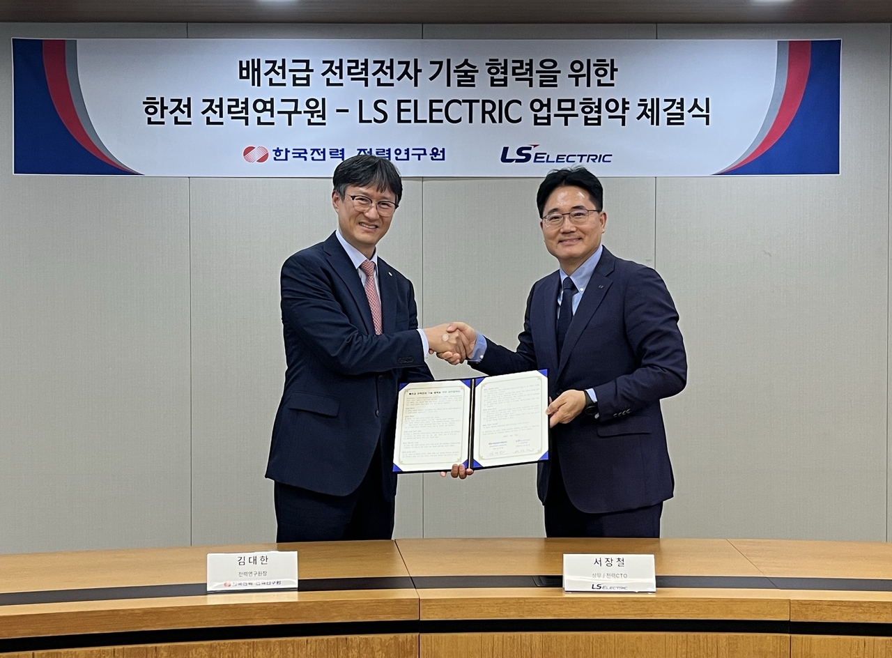 LS Electric and Korea Electric Power Corp. signed an MOU for cooperation on distribution-level power electronics technology at LS Tower in Anyang, Gyeonggi Province, on Monday. Pictured are Seo Jang-cheol, chief technology officer of LS Electric's power division (right), and Kim Dae-han, president of KEPCO's Power Research Institute, at the signing ceremony. [LS Electric]