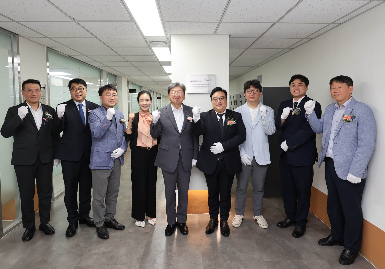 Park Soo-hyun (fourth from right), chief human resources officer of Coupang Fulfillment Services, and Lee Nam-sik, president of Jaeneung University, pose with officials at the plaque-unveiling ceremony for the CFS Industry-Academia Cooperation Lab at Jaeneung University on Monday. [Coupang]