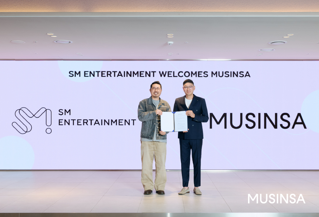 Choi Jae-young (left), chief commerce officer of Musinsa, and Tak Young-jun, chief executive of SM Entertainment, pose for a photo at the MOU signing ceremony on Monday. [Musinsa]