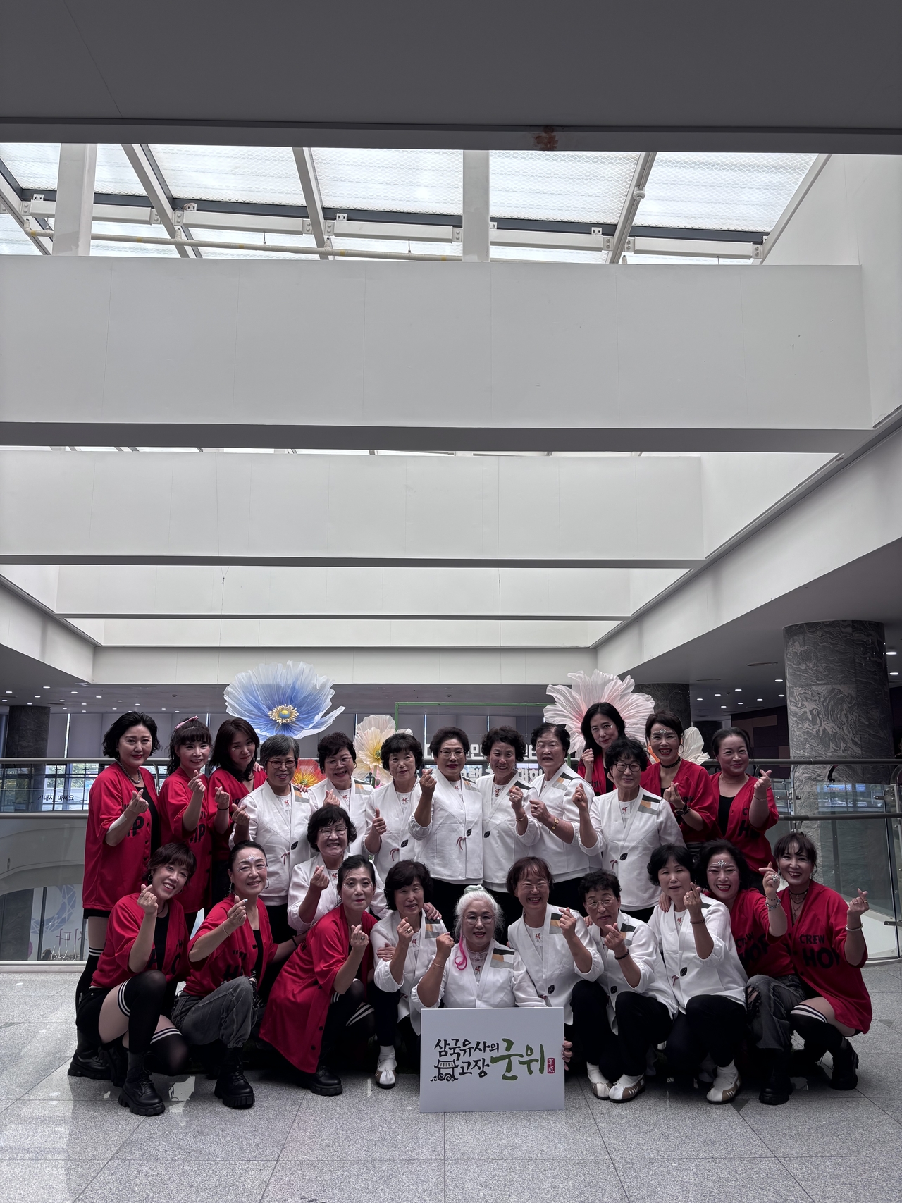 제19회 대구시 주민자치 프로그램 경연대회에 참가한 군위읍 ‘군위흥바람댄스팀’(사진 양쪽·빨간색 의상)과 우보면 ‘군위우보예술단’(사진 중앙·흰색 의상)이 기념촬영을 하고 있다. [군위군 제공]