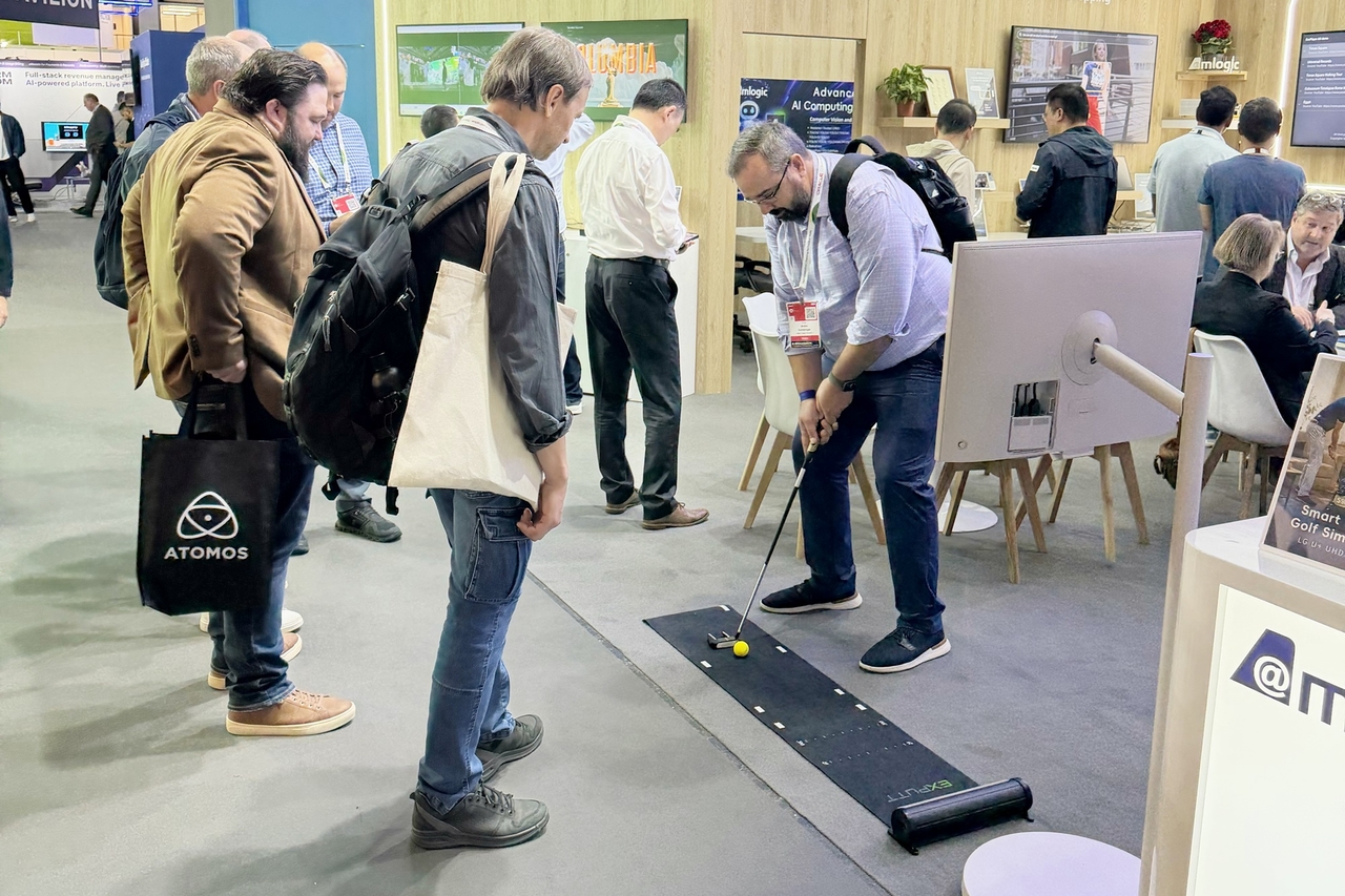 Visitors try out a camera-based golf putting simulator introduced at IBC 2026. [LG Uplus]