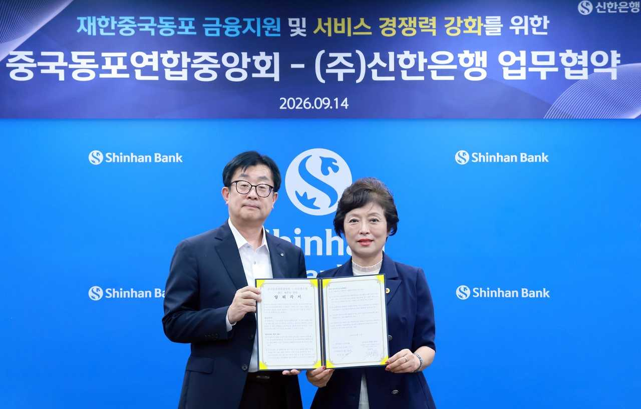 Lee Seung-mok (left), head of Shinhan Bank's customer solutions group, and Kim Mi-jeong, chairwoman of the Korean Chinese Federation, pose for a photo at an MOU signing ceremony held Monday at Shinhan Bank's headquarters in Jung-gu, Seoul. [Shinhan Bank]