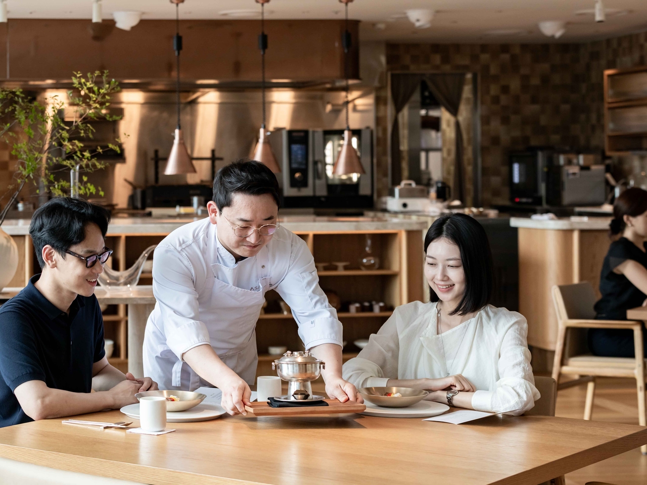 김정환 아사달 셰프가 민어만두 소개를 위해 신선로를 내려놓고 있다. [한화푸드테크 제공]