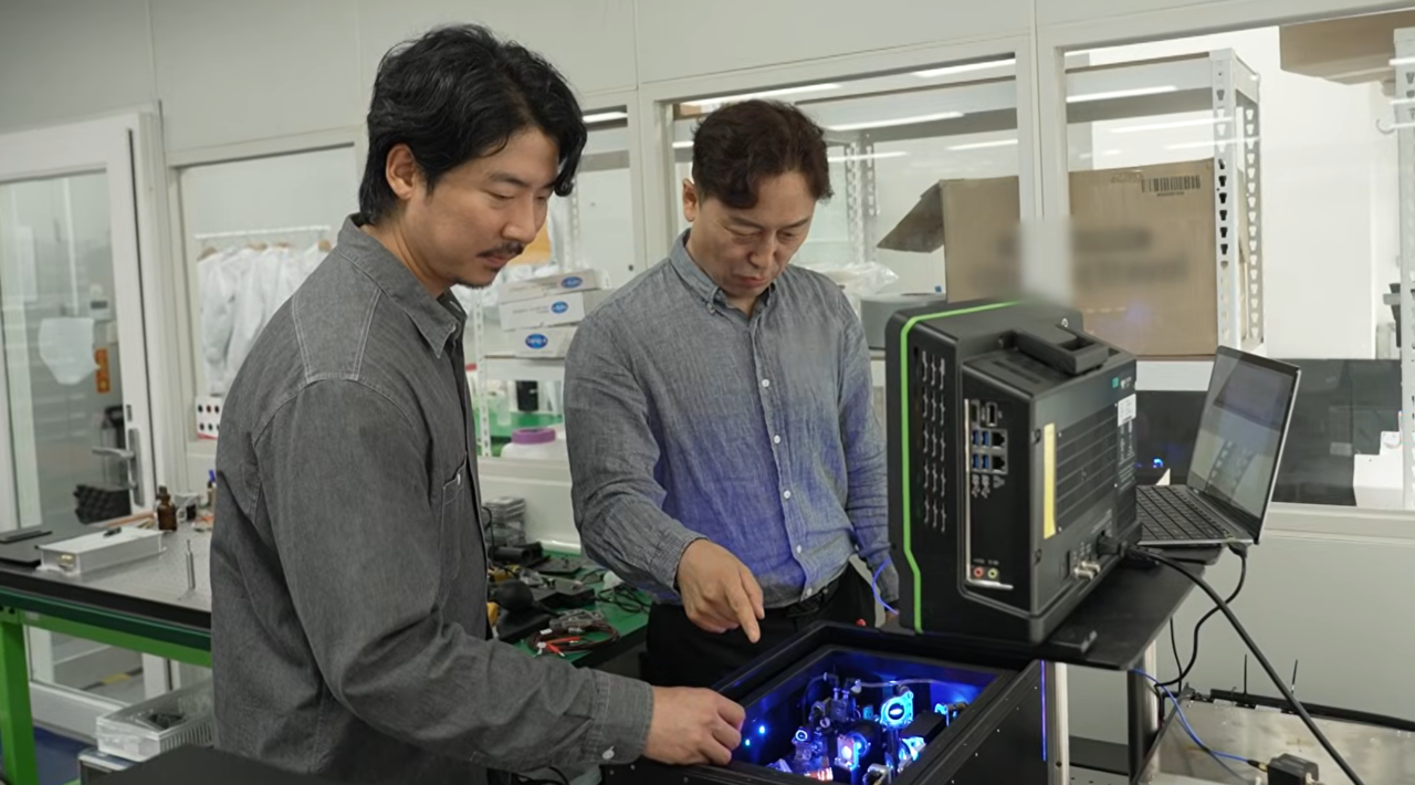 김형우(왼쪽) 블루타일랩 대표와 송동훈 기술이사가 ETRI 융합기술연구생산센터에 있는 회사 연구개발실에서 펨토초 광섬유 레이저 장치를 살펴보고 있다.[연구개발특구진흥재단 제공]