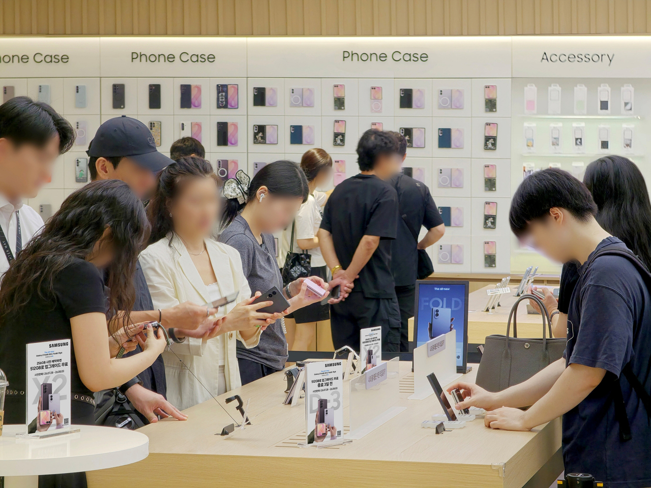 Shoppers examine Samsung Electronics' Galaxy Z Fold8 and Flip8 models at Samsung Gangnam in Seoul on Aug. 4. Samsung said the Z8 series drew a record 1.44 million domestic preorders, with around 70 percent going to the standard Fold8. (Newsis)