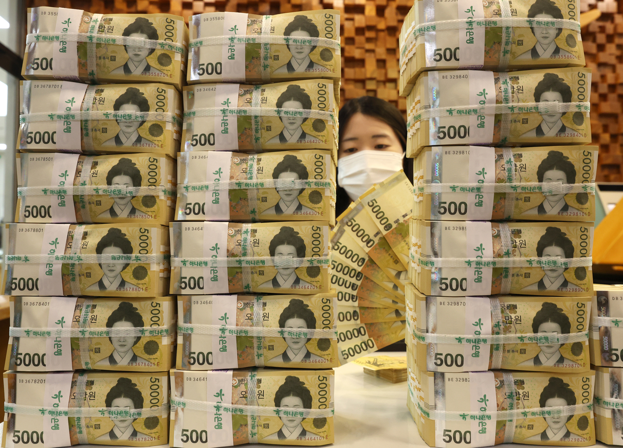 An employee arranges banknotes at a bank in Seoul in this file photo taken on Aug. 21. (Yonhap)
