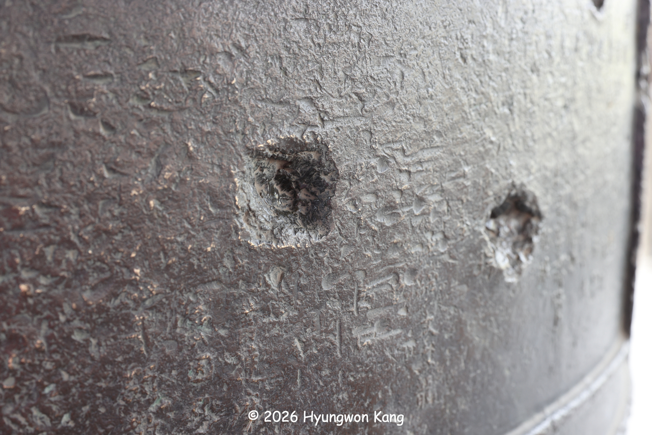 Gunshot impact marks, known as bullet splashes, are visible on the massive Bronze Bell of Yeonboksa, completed in 1346 during the Goryeo period. The bell was struck by aircraft gunfire during the Korean War.  (Hyungwon Kang)