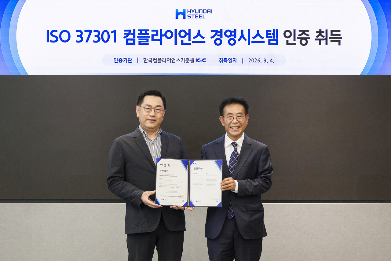 Hyundai Steel Executive Vice President Seo Sang-won, head of the management support division (left), and Korea Fair Competition Federation President Park Jae-gyu pose for a photo at the ISO 37301 certification ceremony. [Hyundai Steel]