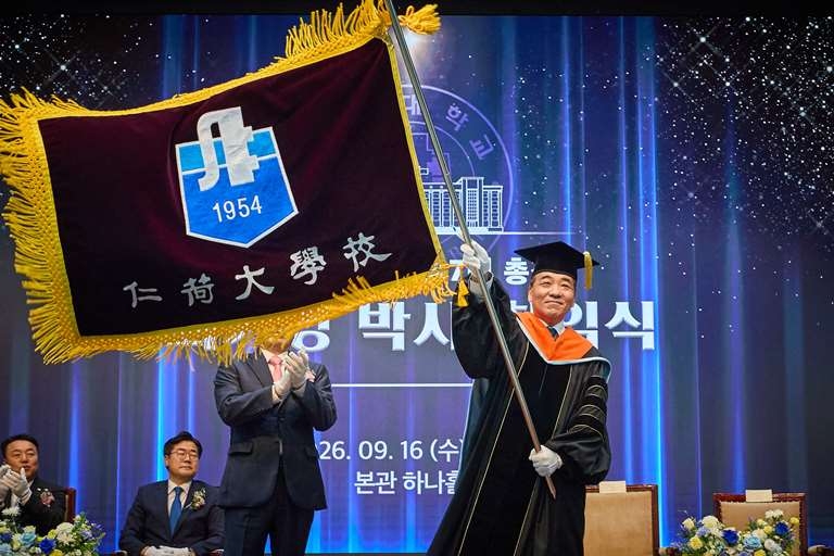 Choi Ki-young waves the university flag at his inauguration ceremony Wednesday. [Inha University]