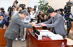 [Herald pic] Defense minister nominee Kang Sin-cheol hands over oath document