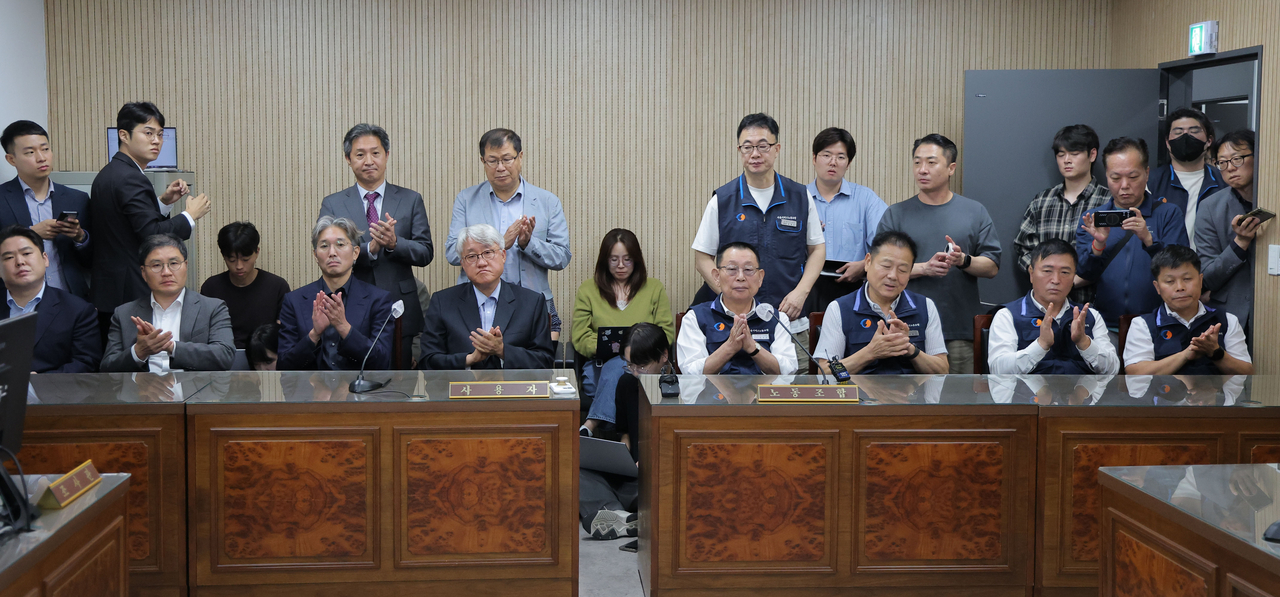 Representatives of Seoul's city bus companies and unionized bus workers clap after reaching a last-minute wage deal at the Seoul Regional Labor Relations Commission in the capital city on Wednesday. (Yonhap)