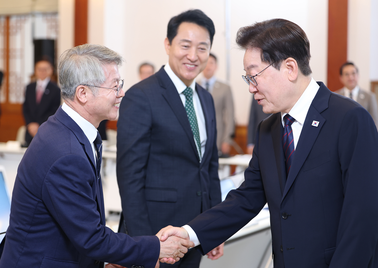 이재명 대통령이 지난달 26일 청와대에서 열린 제10회 중앙지방협력회의에서 민형배 전남광주통합특별시장과 인사하고 있다. 가운데는 오세훈 서울시장. [연합]