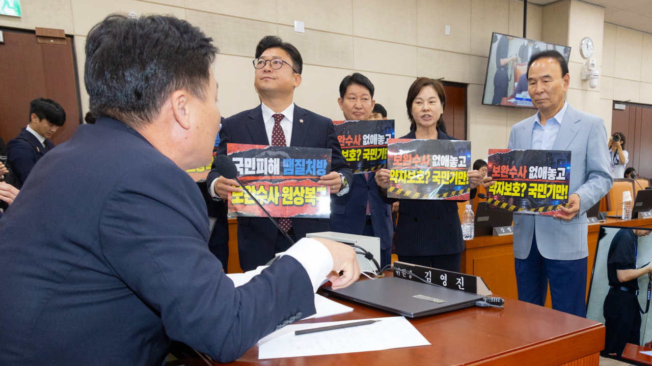 15일 국회에서 열린 행정안전위원회 전체회의에서 국민의힘 소속 행안위원들이 이날 상정된 ‘사회적 약자 대상 7대 범죄’에 대한 보완수사·재수사권을 부여하는 중대범죄수사청법 개정안 처리에 반대 의사를 밝히며 손팻말을 들고 김영진 행안위원장에게 항의하고 있다. [연합]