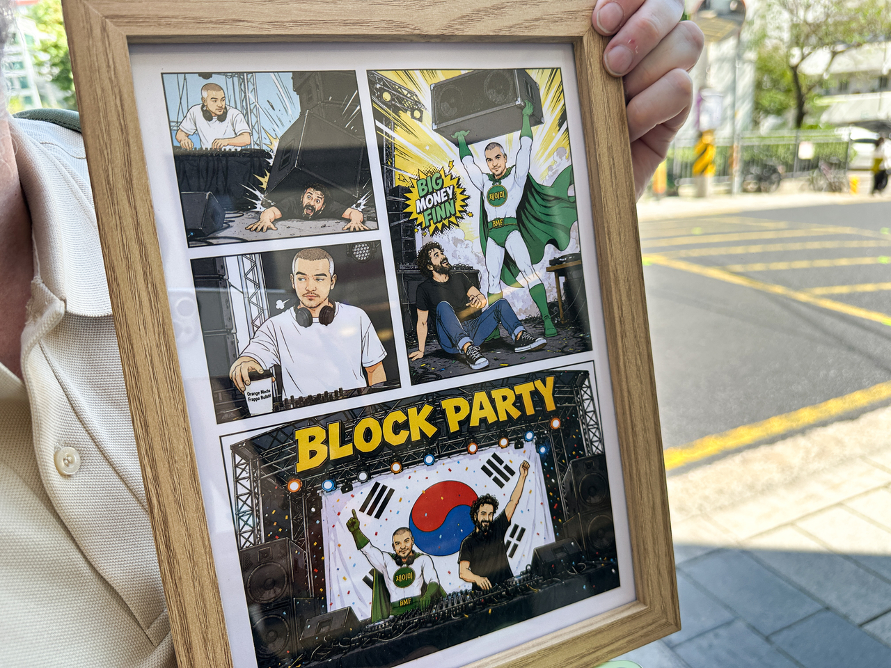 Finn holds up a comic-style portrait gifted to him by his friend, DJ Luke No-Wave, showing his many lives as a DJ, festival organizer and longtime wrestling fan. (Tammy Park/The Korea Herald)