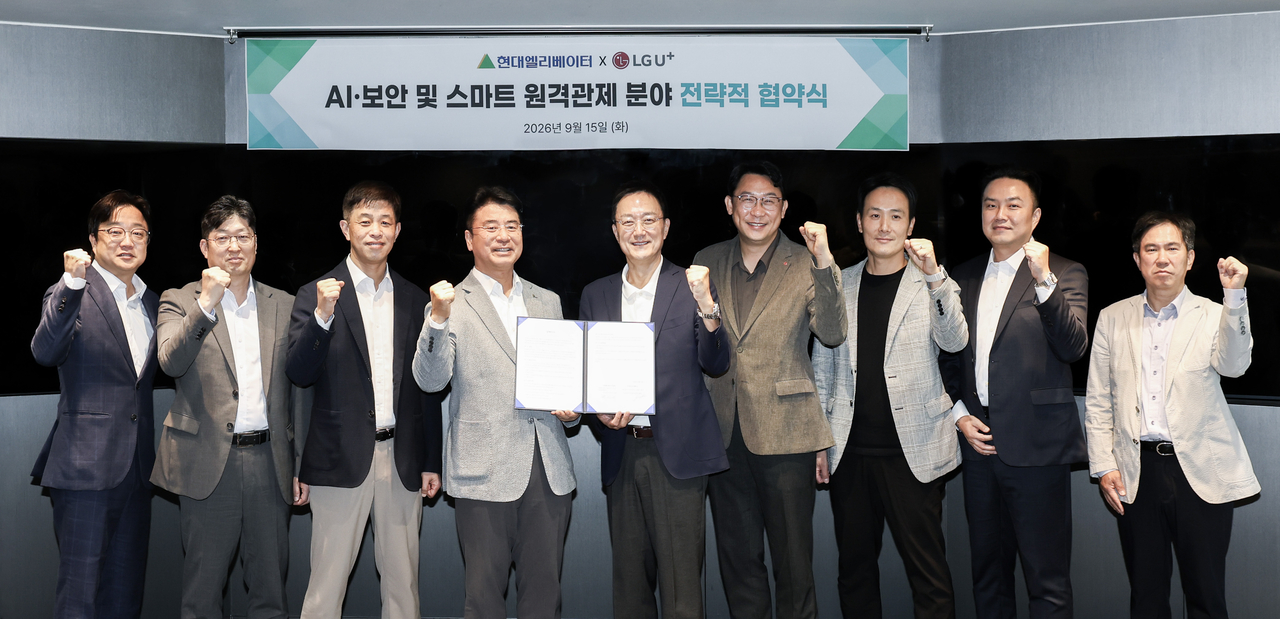 Hyundai Elevator Service Division Executive Vice President Choi Seok-gyu (fourth from left) and LG Uplus Enterprise Customer Group Executive Vice President Im Jang-hyeok (fifth from left) pose for a photo after signing an MOU on wireless service and AI and security cooperation for a smart remote-monitoring platform at the Hyundai Group Building in Jongno-gu, Seoul, on Tuesday. [Hyundai Elevator]