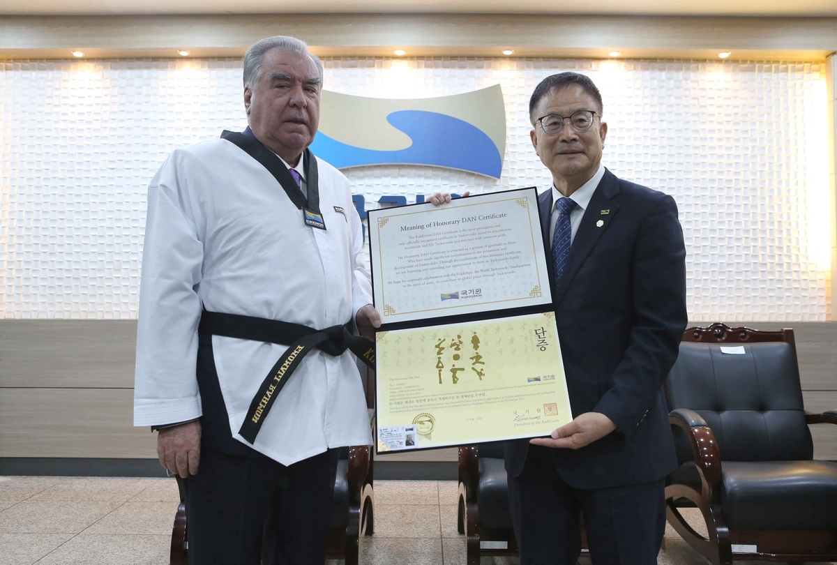 Tajik President Emomali Rahmon (left) poses in a taekwondo uniform after being presented with an honorary ninth-dan certificate at Kukkiwon in Seoul on Sept. 17, 2026, in this photo provided by Kukkiwon. (Kukkiwon)
