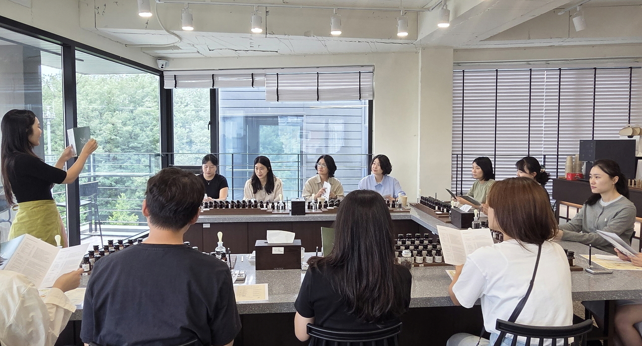 Participants in the "Integrity Comma: Filling the Heart With Fragrance" program craft their own personal perfumes at a local perfume workshop in Yongsan-gu.