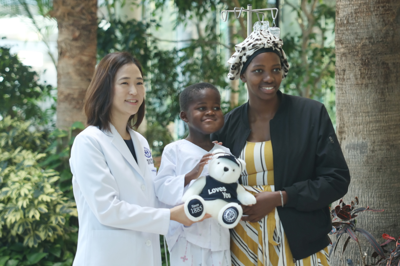 Professor Kim Da-hee (left), Thandolubanduzi and his mother pose for a photo before his discharge. [Provided by Severance Hospital]