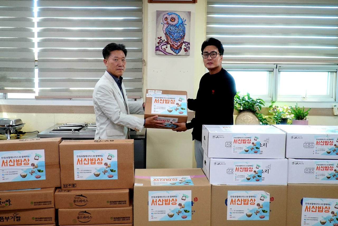 한화토탈에너지스 관계자가 농수산물을 전달하는 모습. [한화토탈에너지스 제공]