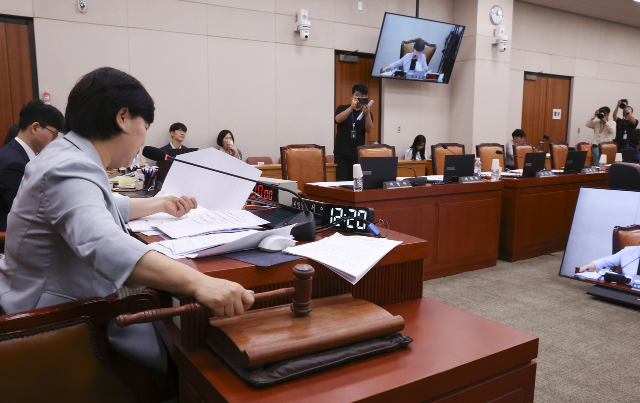 Democratic Party Rep. Seo Young-kyo (left) hits a gavel during a general meeting of the Legislation and Judiciary Committee on Thursday as People Power Party lawmakers walked out to protest the Democratic Party's unilateral push to confirm Democratic Party Rep. Kim Seung-won as the Justice Minister. (Newsis)
