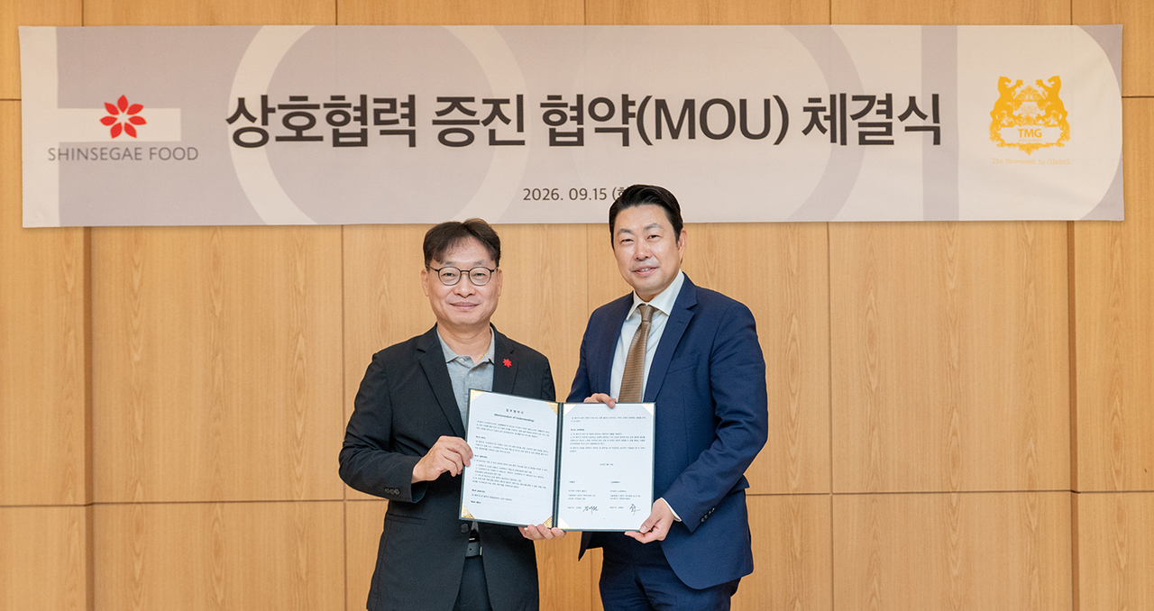 Shinsegae Food CEO Im Hyeong-seop (left) and TMG Holdings CEO Kim Jae-won pose after signing an MOU at Shinsegae Food's headquarters in Seongdong-gu, Seoul, on Tuesday to expand product development and distribution using premium ingredients. [Shinsegae Food]