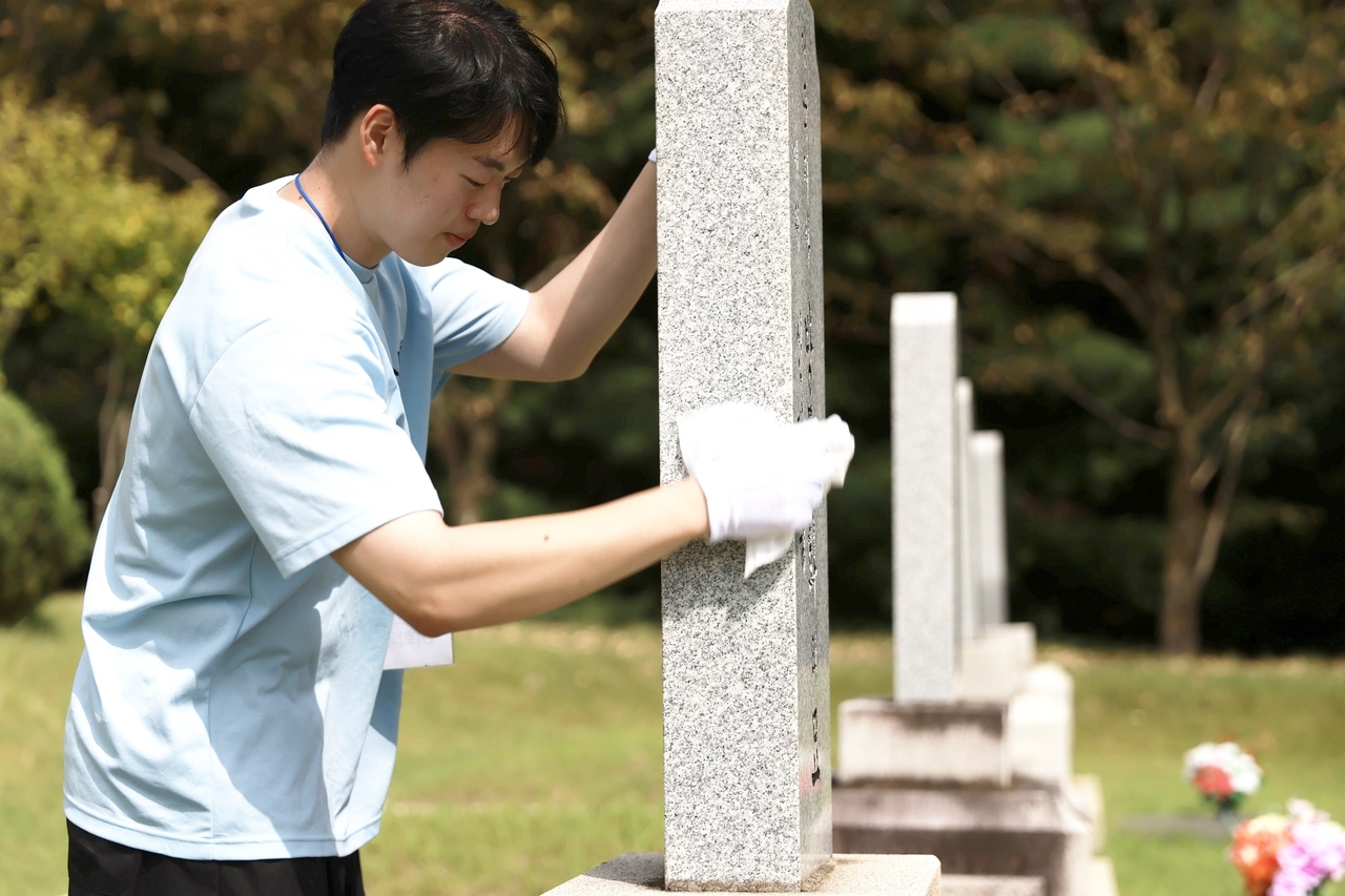 18일 대전 현충원에서 국민연금 대학생 홍보대사들이 묘역정비 활동을 하고 있다. [국민연금공단 제공]