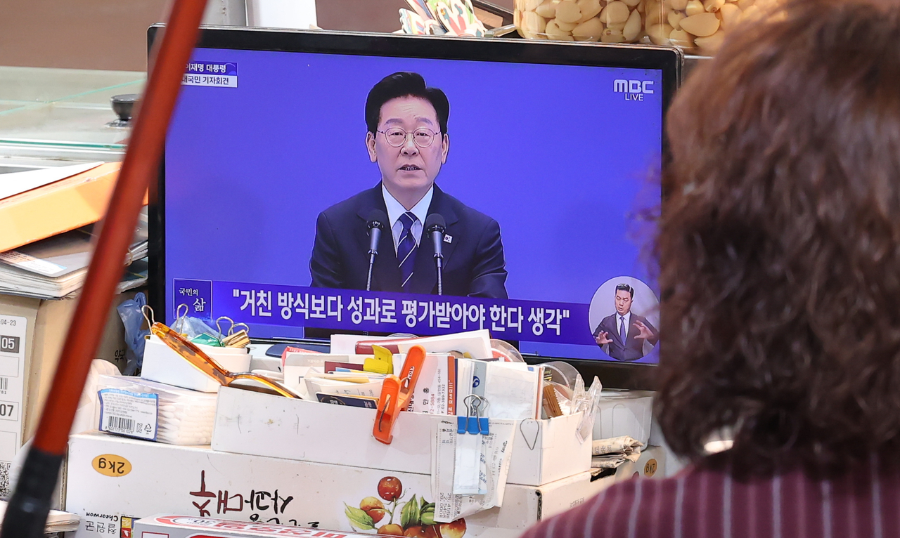 18일 오전 서울 서대문구 인왕시장에서 상인들이 이재명 대통령 대국민 기자회견 생중계 방송을 시청하고 있다. 윤창빈 기자