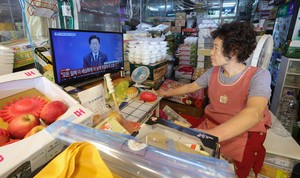 [Herald pic] Market vendors watch President Lee's opening remarks