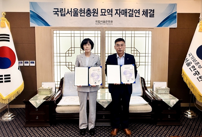 Song Hyeon-suk, left, head of the management division at Seoul National Cemetery, poses for a photo with Daiso representatives. [Daiso]