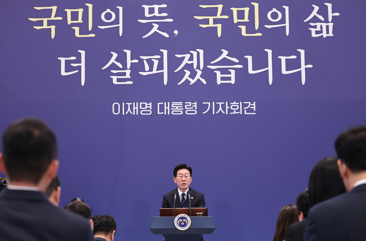 President Lee Jae Myung speaks at a news conference at Cheong Wa Dae on Friday, against a backdrop bearing the slogan, “We will heed the people’s will and take greater care of their lives.” (Yonhap)
