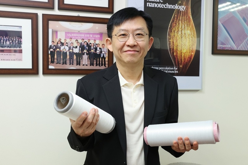 Professor Kim Sang-uk holds a graphene fiber. [Provided by KAIST]