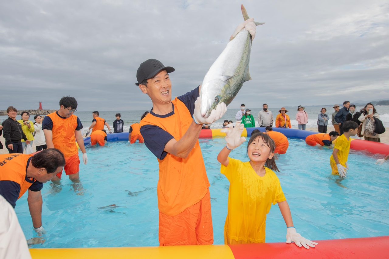 Visitors catch live fish with their bare hands at the Goseong Pollock Festival. Photo from last year's event.