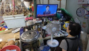 [Herald pic] Merchants watch president's press conference