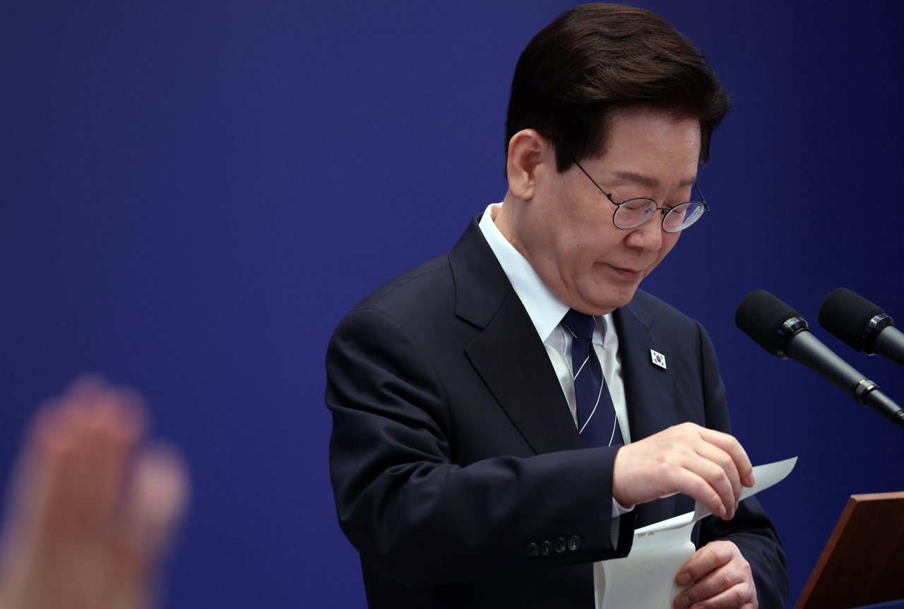 이재명 대통령이 지난 18일 청와대 영빈관에서 열린 기자회견에서 취재진 질문을 들으며 메모지를 보고 있다. [연합]