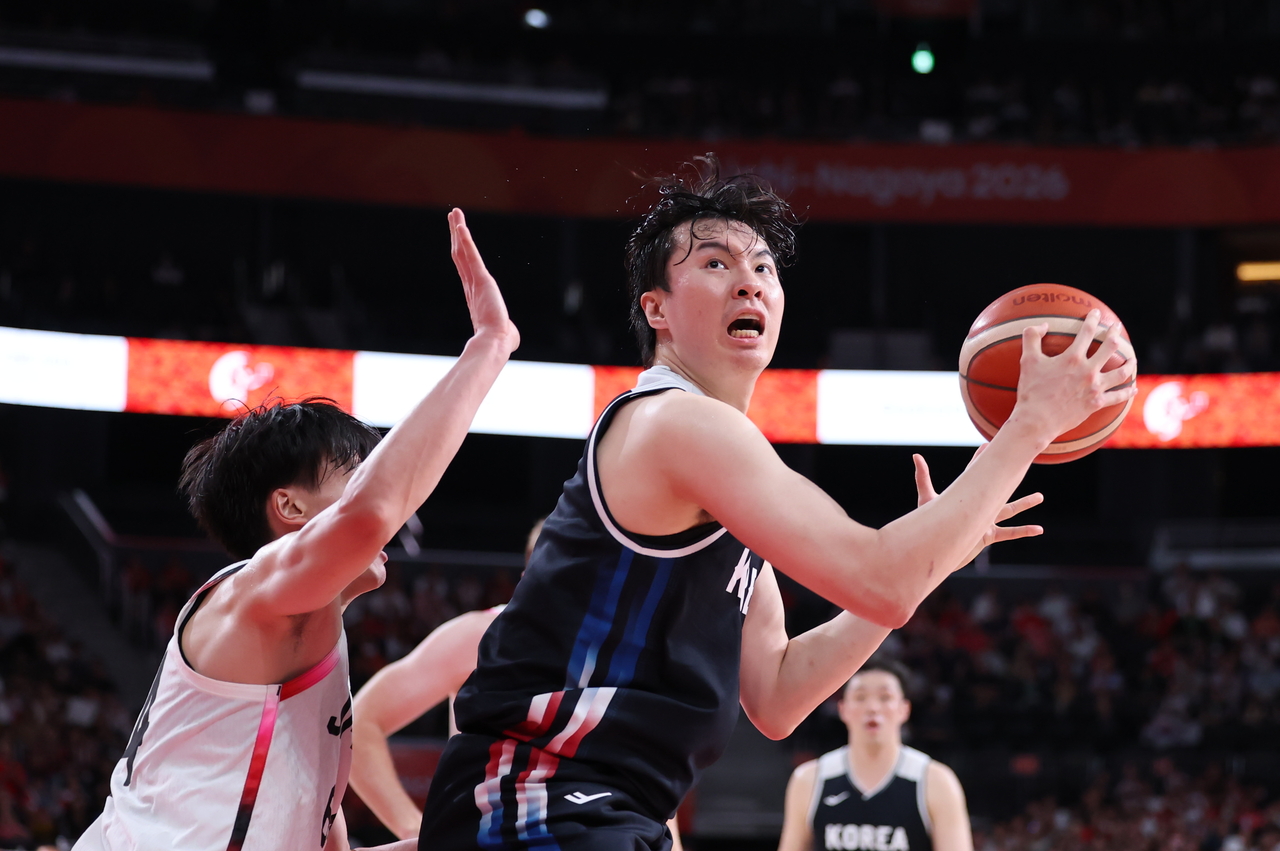 Lee Hyun-jung of South Korea (right) attempts a shot against Japan during the men's basketball gold medal game at the Asian Games at Aichi International Arena in Nagoya, Japan, on Sunday. (Yonhap)