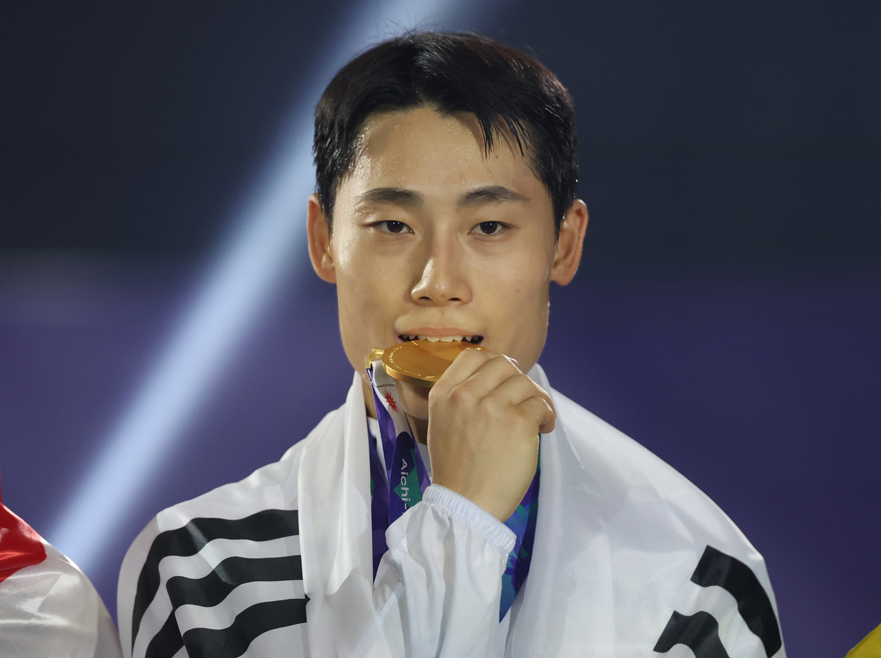 Lee Jun-suk of South Korea bites his gold medal won in the men's singles teqball event at the Asian Games at Nagoya City Higashi Sports Center in Nagoya, Japan, on Sunday. (Yonhap)
