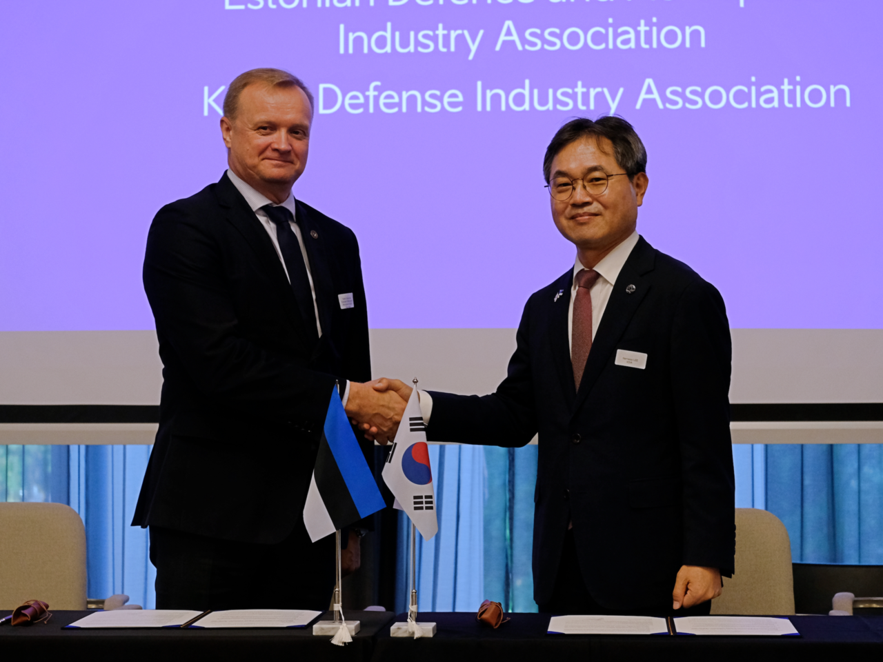 Lee Nam-woo (right), executive vice chairman of the Korea Defense Industry Association, shakes hands with Kalev Koidumae, CEO of the Estonian Defence and Aerospace Industry Association, after signing a memorandum of understanding at a hotel in Tallinn, Estonia, on Thursday. (Joint Press Corps)